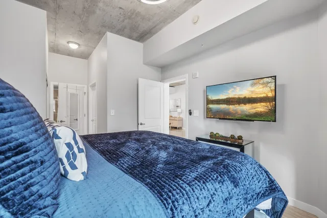 a bedroom with bed and a flat screen tv