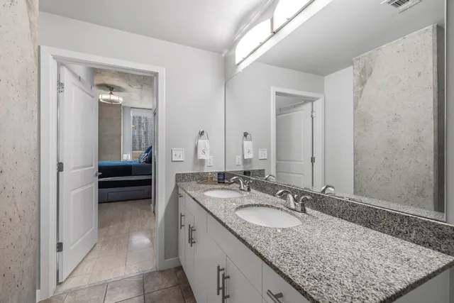 a en suite bathroom with a granite countertop sink and a mirror