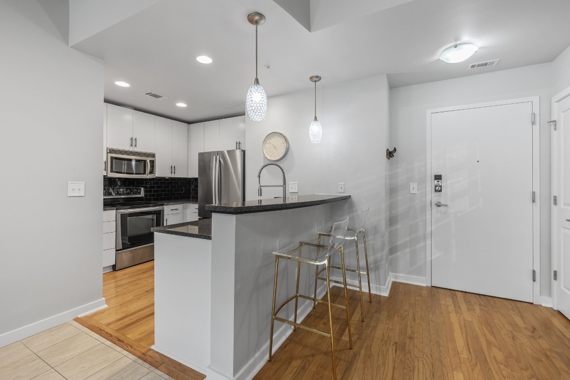 360 Nueces Street, Unit 911 Austin, TX 78701 - Photo 4 of 31 a kitchen with stainless steel appliances granite countertop a refrigerator a sink a stove and oven with wooden floor