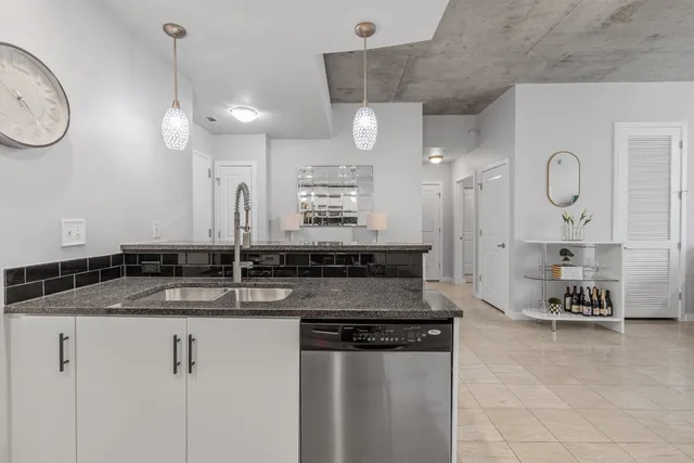 a kitchen with granite countertop a sink a counter space cabinets and stainless steel appliances