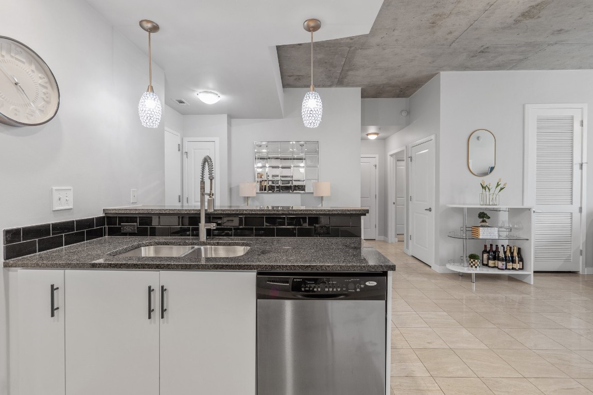 360 Nueces Street, Unit 911 Austin, TX 78701 - Photo 6 of 31 a kitchen with granite countertop a sink a counter space cabinets and stainless steel appliances