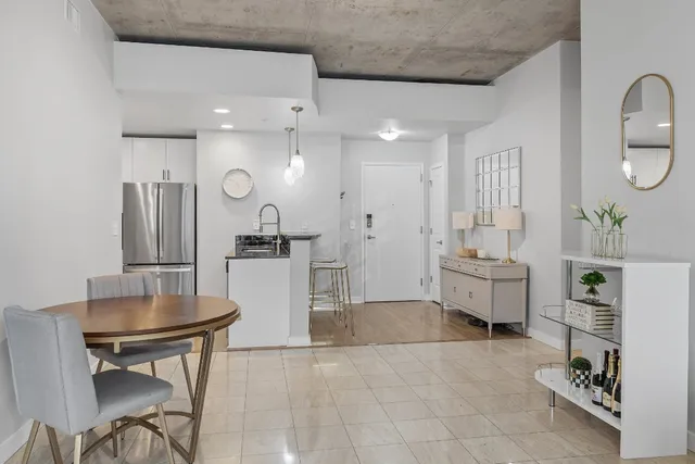 a room with stainless steel appliances kitchen island granite countertop a table and chairs in it