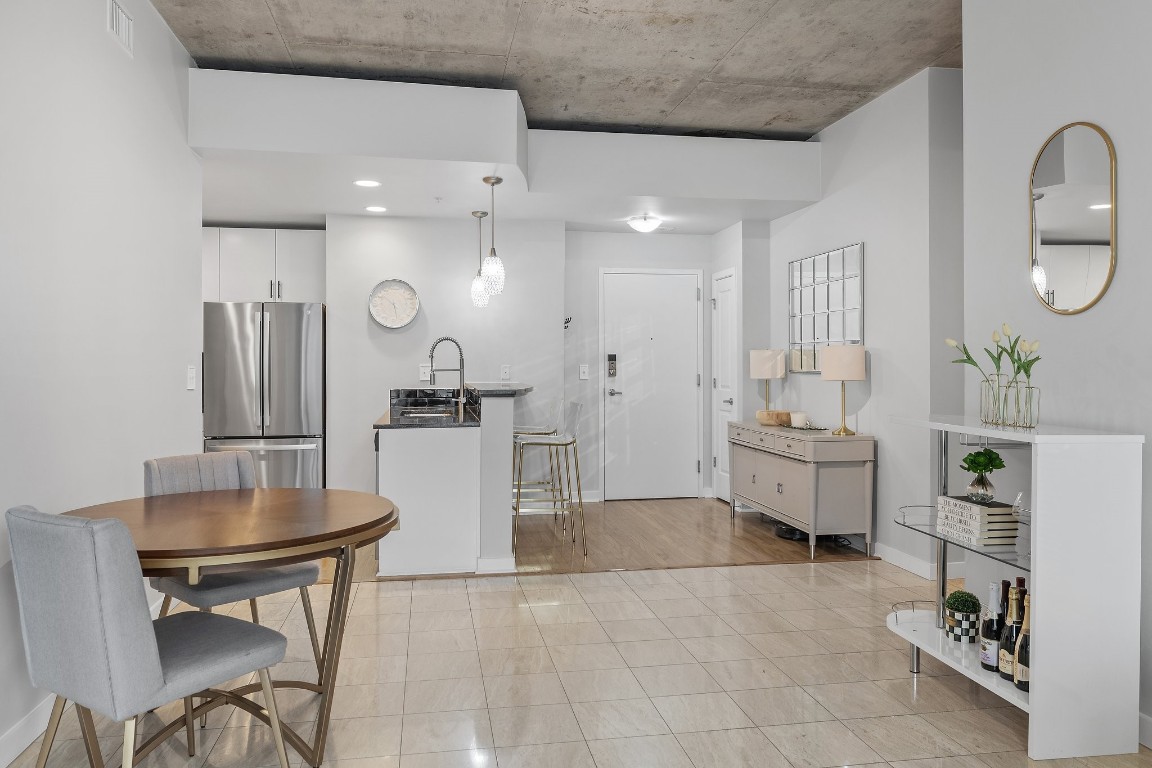 360 Nueces Street, Unit 911 Austin, TX 78701 - Photo 9 of 31 a room with stainless steel appliances kitchen island granite countertop a table and chairs in it