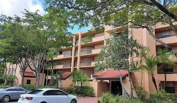 a front view of a building with a garden and plants