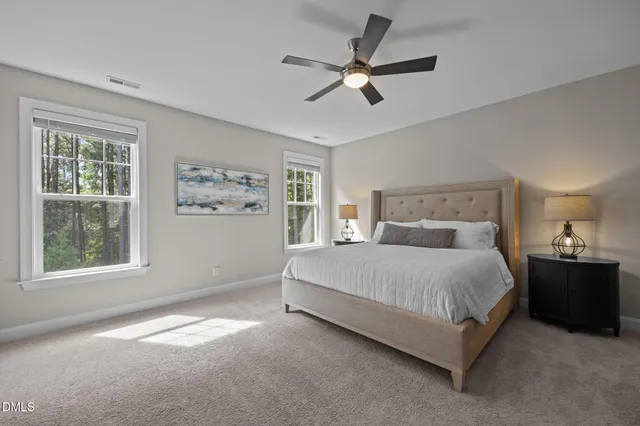 a bedroom with a large bed and ceiling fan