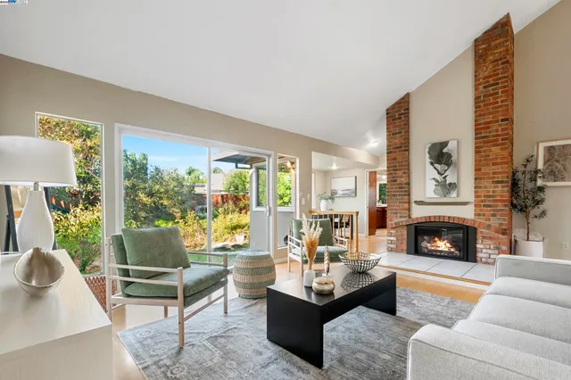 a living room with furniture fireplace and a large window