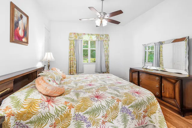 a large bed sitting in a bedroom next to a window and a chandelier