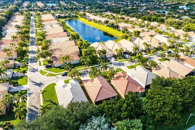 an aerial view of a house with swimming pool and large trees