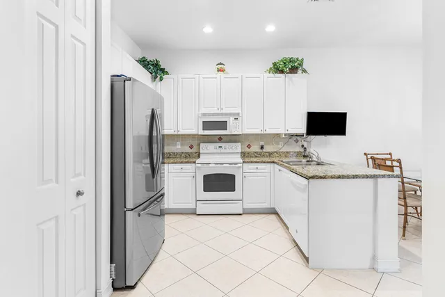 a kitchen with stainless steel appliances granite countertop a sink and a window