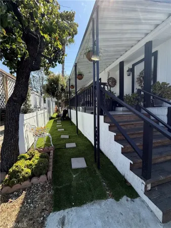 a view of a porch with couches and table and chairs under an umbrella