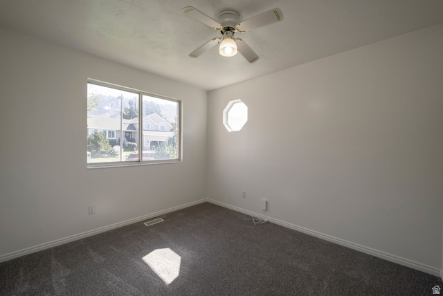11922 Bluff View Drive Sandy, UT 84092 - Photo 12 of 30 Empty room featuring dark carpet and a ceiling fan