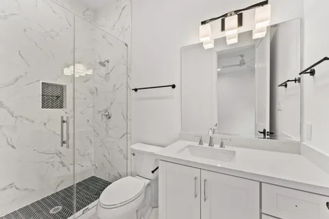 a bathroom with a sink toilet and shower