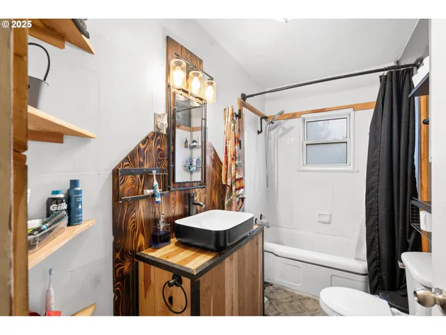 a bathroom with a sink a toilet a mirror and shower