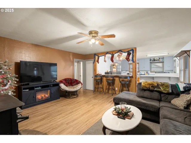 a living room with furniture a flat screen tv and kitchen view