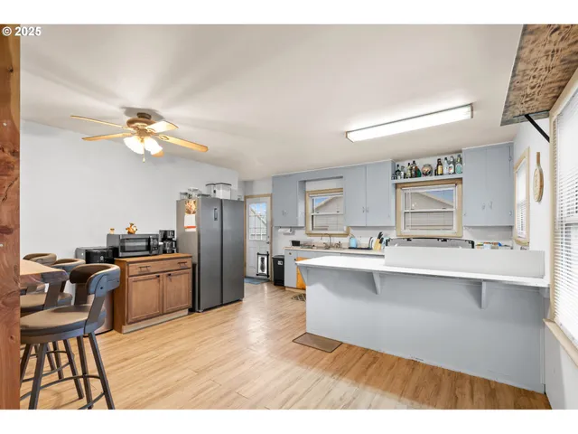 a open kitchen with stainless steel appliances granite countertop a sink dishwasher and a stove with wooden floor