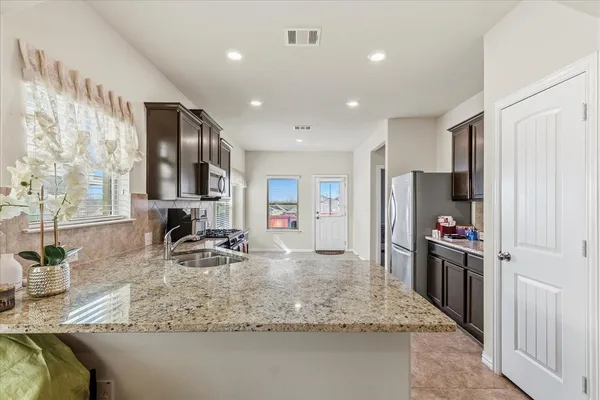 a kitchen with stainless steel appliances granite countertop a sink stove and refrigerator