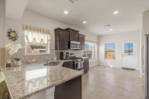 a kitchen with stainless steel appliances granite countertop a sink stove and refrigerator
