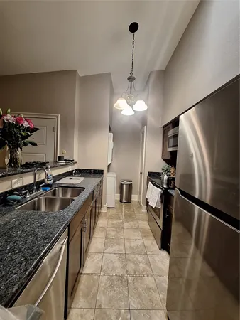 a kitchen with granite countertop a sink stainless steel appliances and a counter space