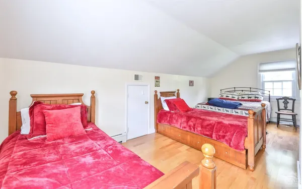 a bedroom with a bed and a potted plant on th dresser