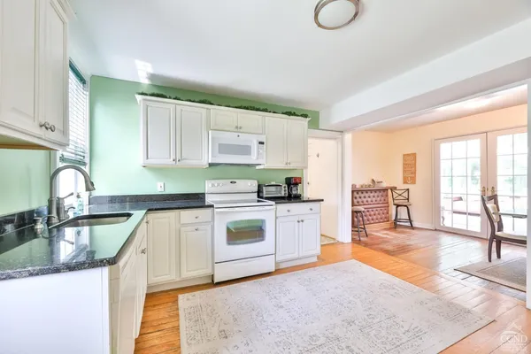 a kitchen with granite countertop a stove sink and cabinets