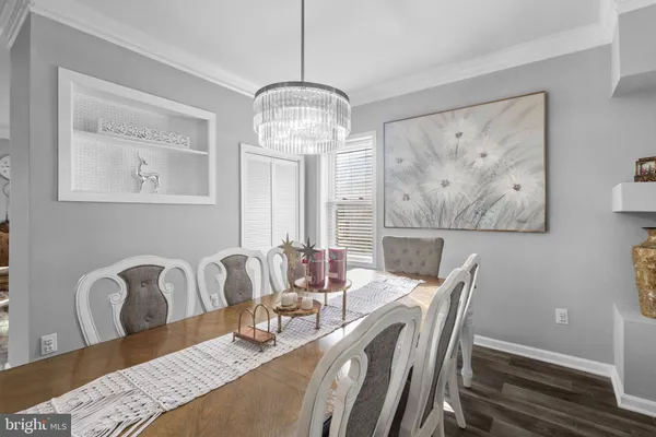 a dining room with furniture potted plants and wooden floor