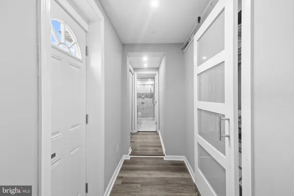 a kitchen with stainless steel appliances granite countertop a refrigerator a sink dishwasher a stove and white cabinets with wooden floor