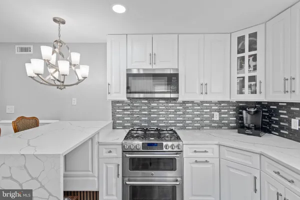 a kitchen with stainless steel appliances a refrigerator and wooden floor