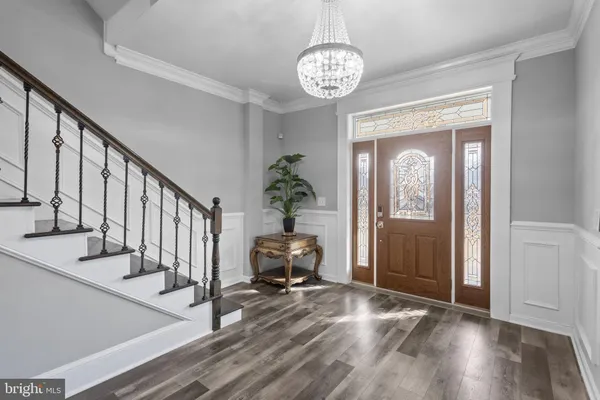 a hallway with wooden floor and a potted plant