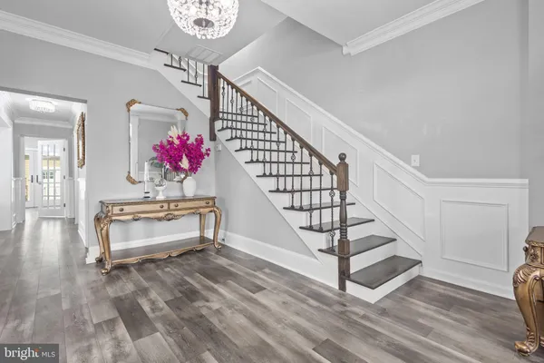 a view of a hallway with wooden floor and a chandelier