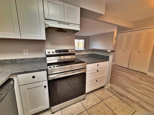 a kitchen with granite countertop white cabinets and white appliances