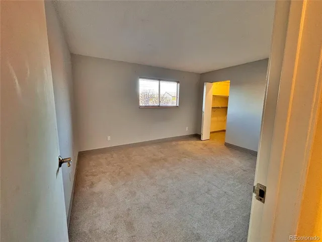 an empty room with a window and a bathroom