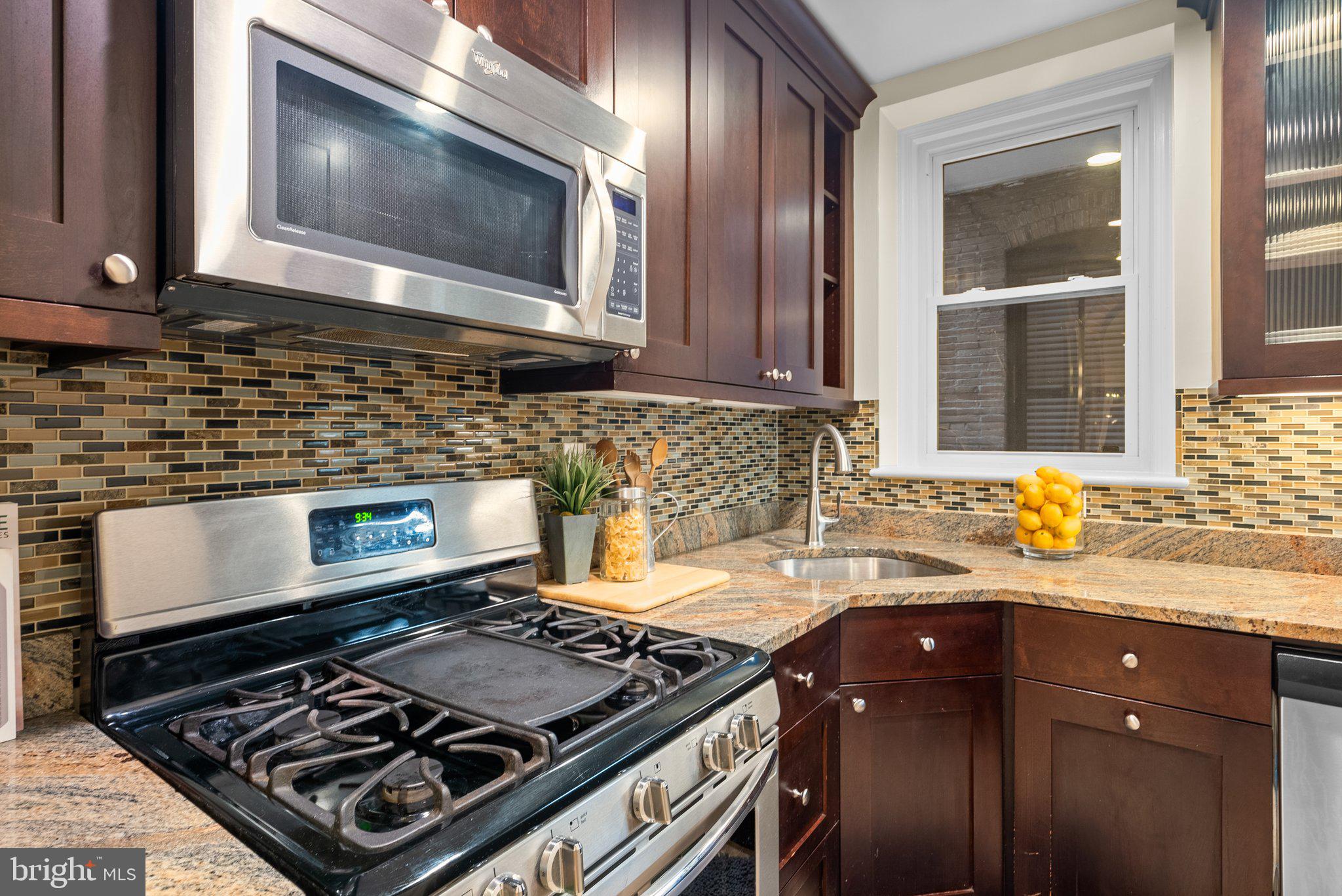 410 11th Street Northeast, Unit 6 Washington, DC 20002 - Photo 16 of 28 a kitchen with a stove a microwave a sink and cabinets