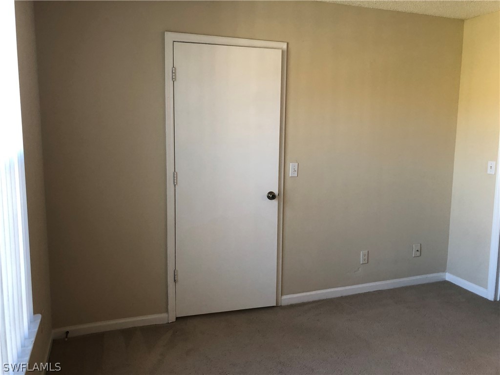 13561 Eagle Ridge Drive, Unit 1025 Fort Myers, FL 33912 - Photo 5 of 11 an empty room with a door