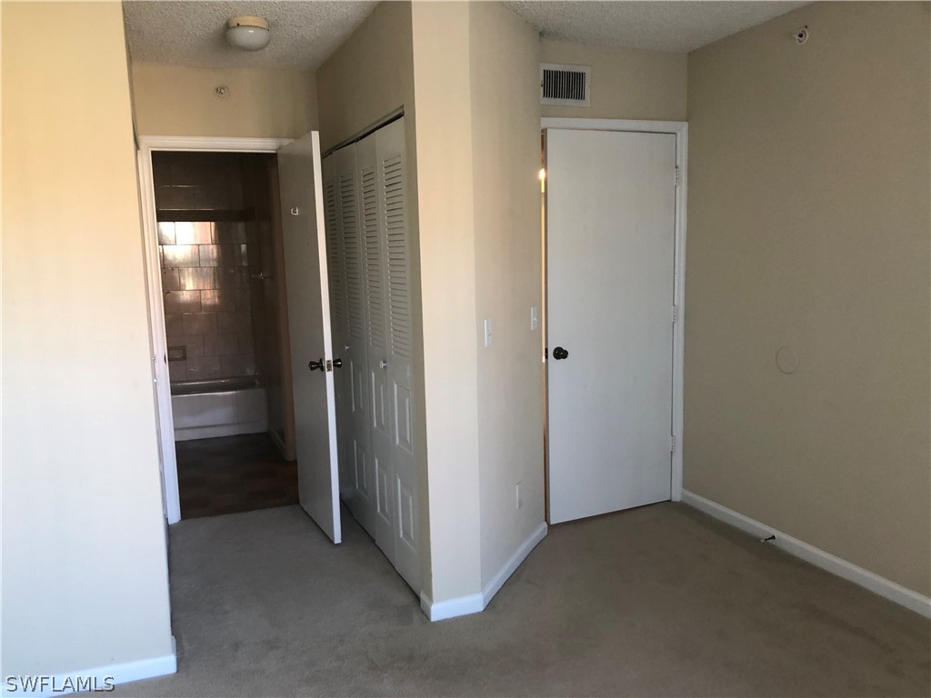 13561 Eagle Ridge Drive, Unit 1025 Fort Myers, FL 33912 - Photo 8 of 11 a view of an empty room with closet and a bathroom