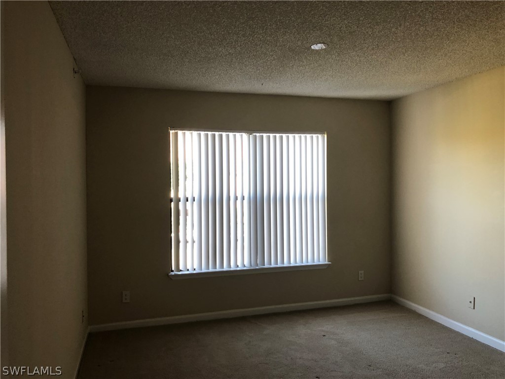 13561 Eagle Ridge Drive, Unit 1025 Fort Myers, FL 33912 - Photo 9 of 11 an empty room with a window