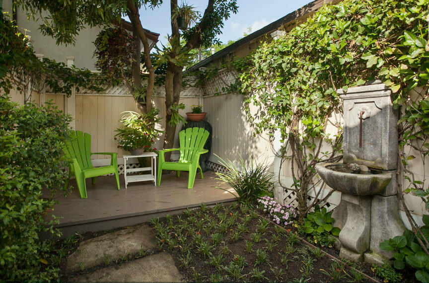 1219 Laguna Street Santa Barbara, CA 93101 - Photo 8 of 25 a view of a backyard with table and chairs potted plants and large tree