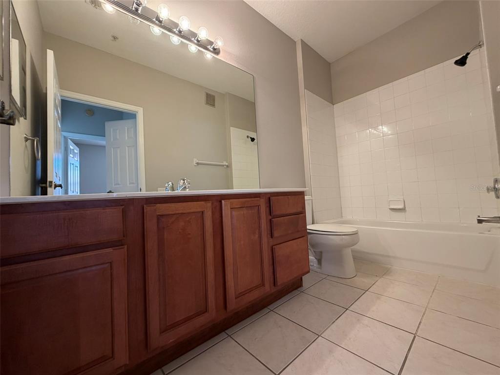 13524 Turtle Marsh Loop, Unit 621 Orlando, FL 32837 - Photo 13 of 14 a bathroom with a toilet a sink and mirror