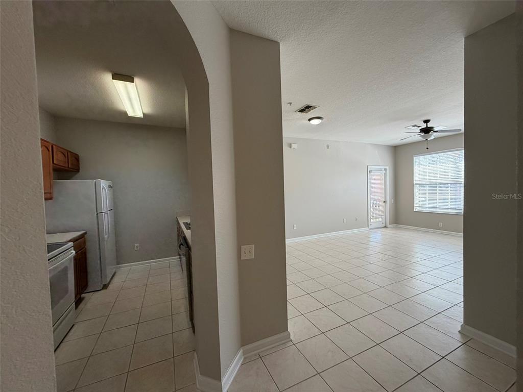 13524 Turtle Marsh Loop, Unit 621 Orlando, FL 32837 - Photo 4 of 14 a view of a kitchen with a refrigerator and cabinets