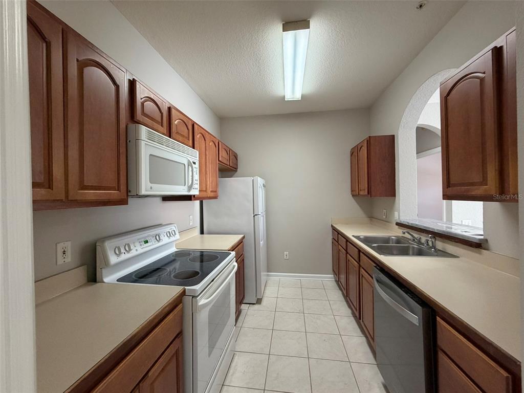 13524 Turtle Marsh Loop, Unit 621 Orlando, FL 32837 - Photo 5 of 14 a kitchen that has a sink and a stove