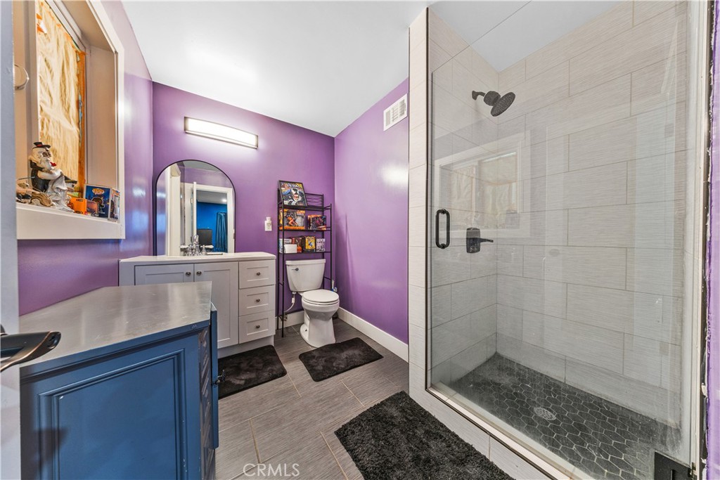20200 Lassen Street Chatsworth, CA 91311 - Photo 30 of 32 a bathroom with a sink a toilet a mirror and shower