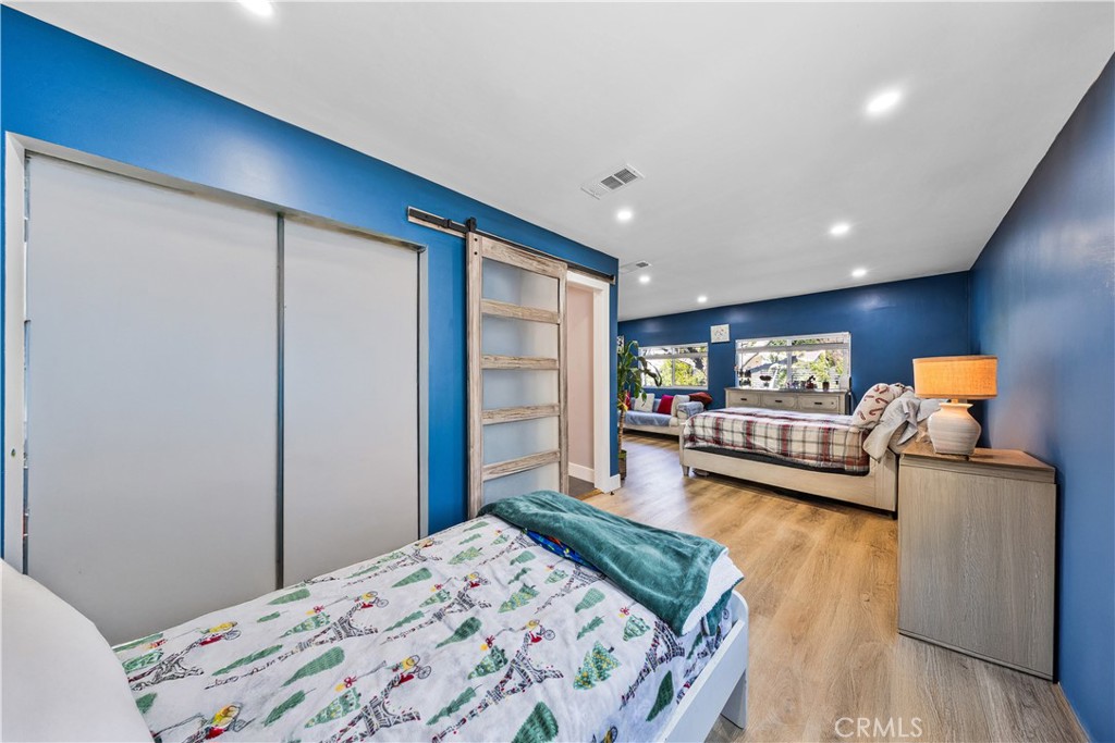 20200 Lassen Street Chatsworth, CA 91311 - Photo 31 of 32 a bedroom with a bed closet and a flat tv screen