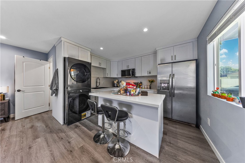 20200 Lassen Street Chatsworth, CA 91311 - Photo 7 of 32 a kitchen with a refrigerator a stove and a wooden floors