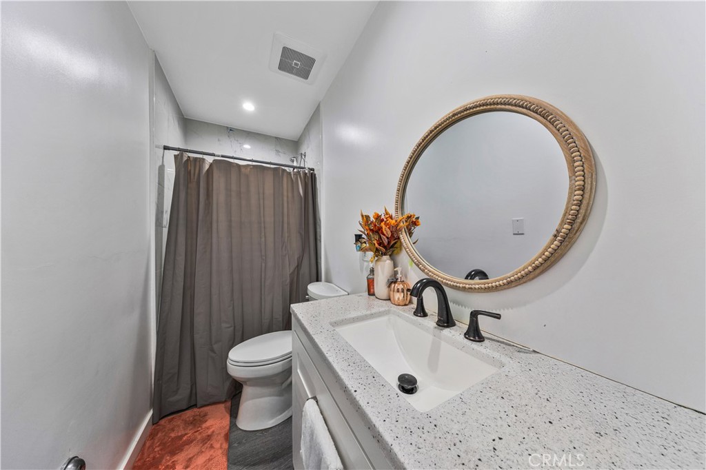 20200 Lassen Street Chatsworth, CA 91311 - Photo 10 of 32 a bathroom with a sink a toilet and a mirror