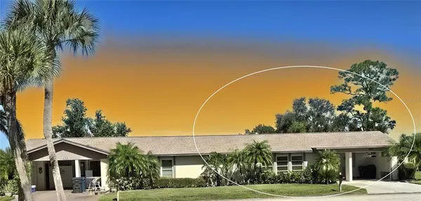 a view of a white house with a big yard and potted plants