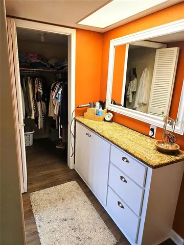 a en suite bathroom with a granite countertop sink and a mirror