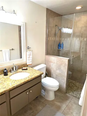 a bathroom with a granite countertop sink toilet and shower