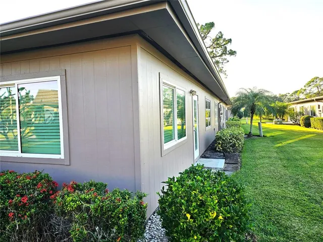a view of a backyard with potted plants and floor to ceiling window