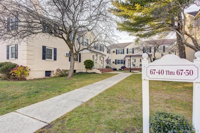 a sign board with yard and car parked