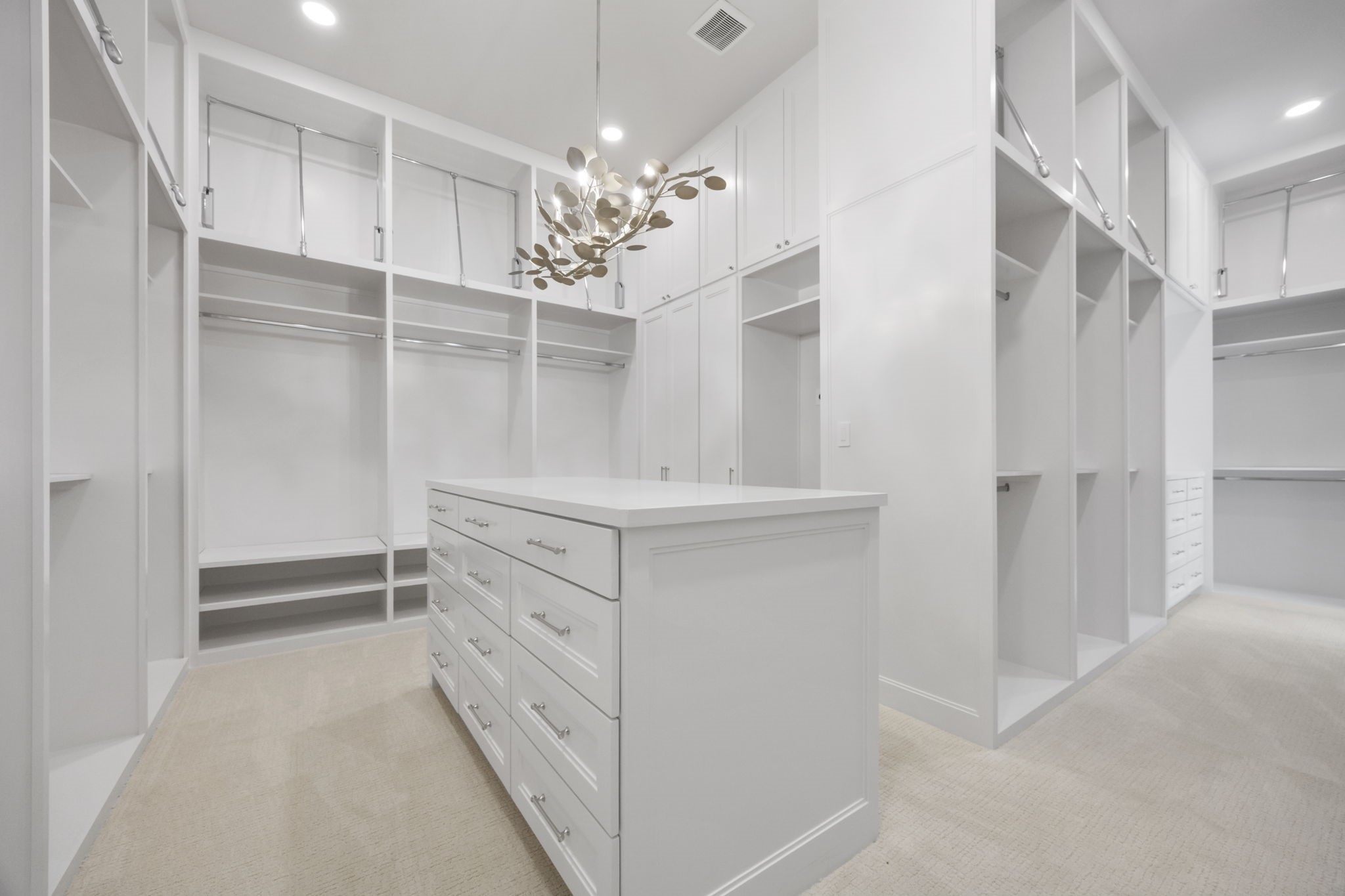 4233 Two Gun Way Katy, TX 77494 - Photo 22 of 47 Wonderfully oversized primary closet with packing island and gold and crystal accented chandelier.