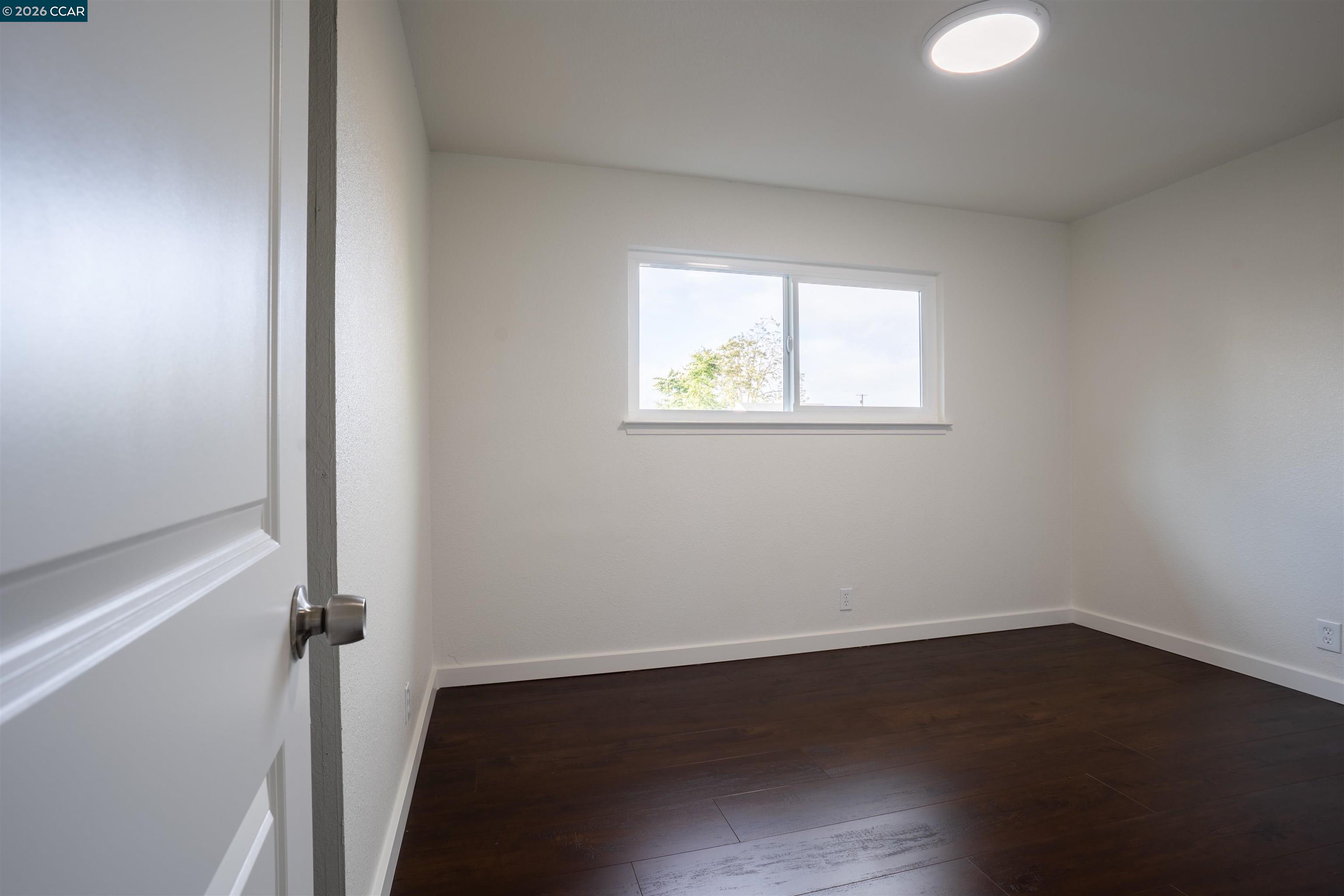 58 Solano Avenue Bay Point, CA 94565 - Photo 9 of 23 an empty room with wooden floor and windows